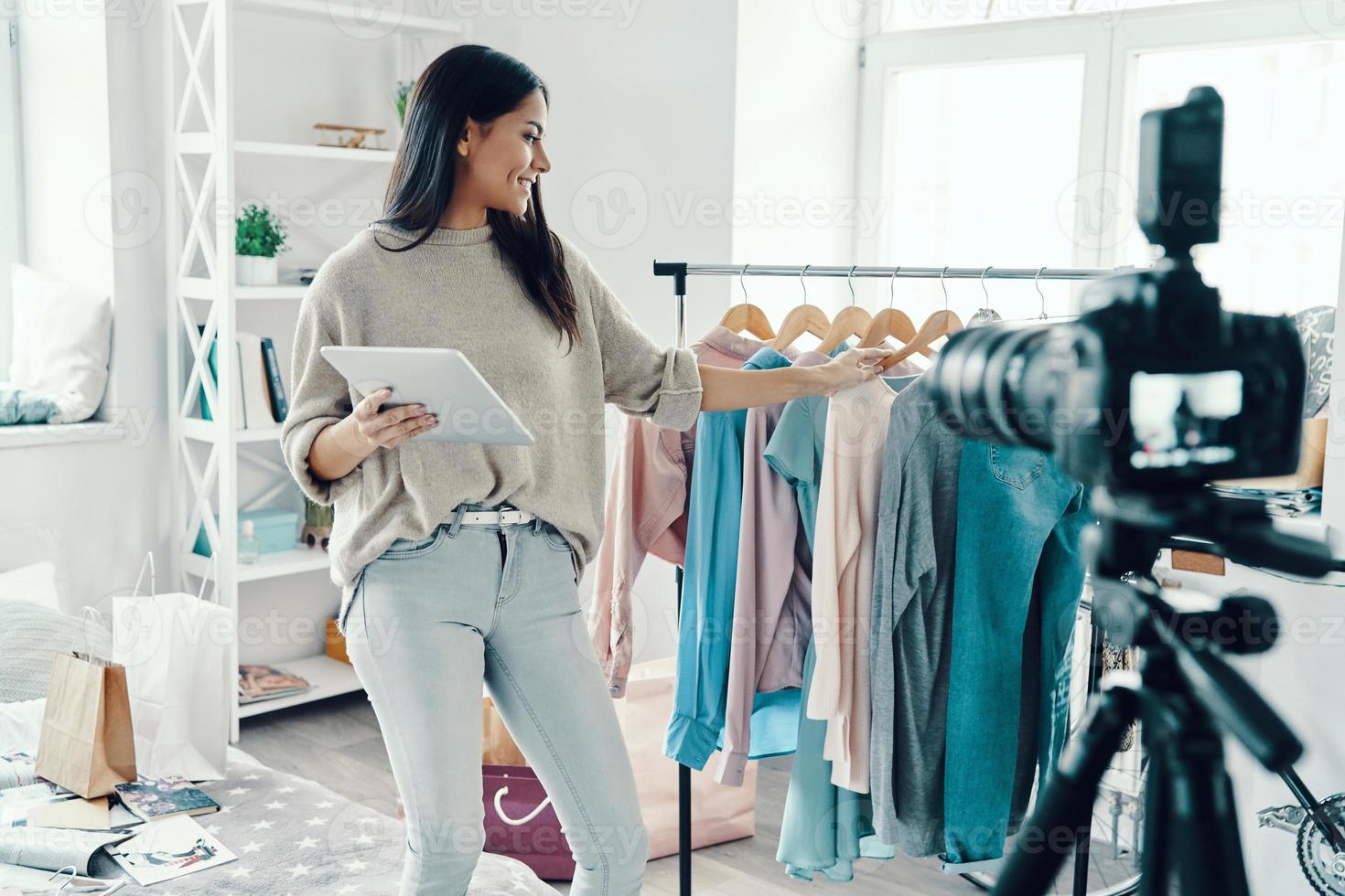 Schöne junge Frau in Freizeitkleidung, die Social-Media-Videos macht, während sie Zeit zu Hause verbringt foto