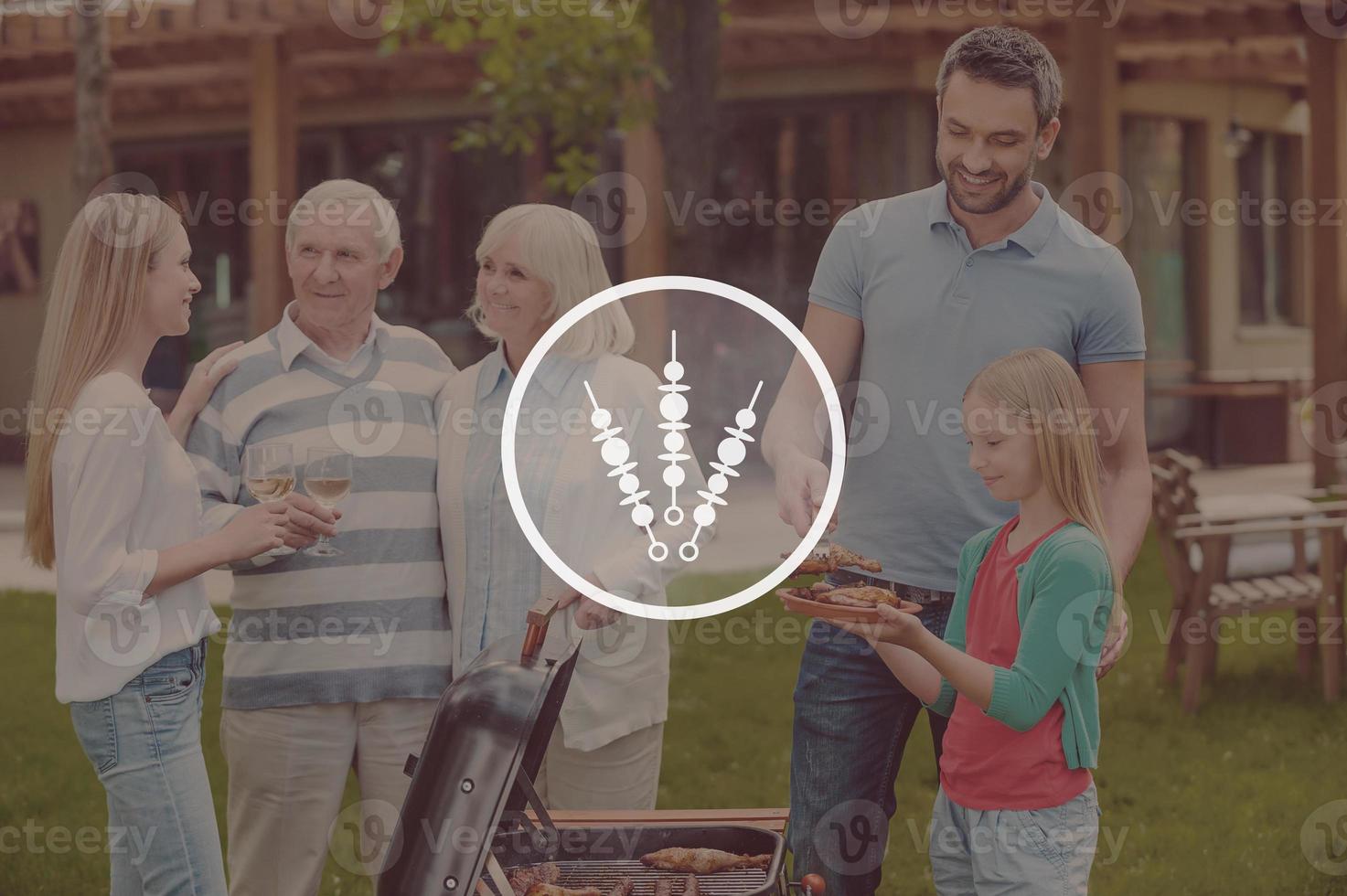 Grillzeit. glückliche Familie mit fünf Personen, die Fleisch auf dem Grill auf dem Hinterhof grillen foto