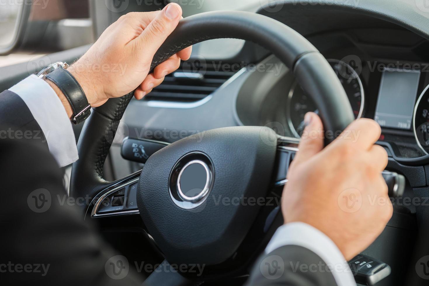 Mann Lenkrad. Nahaufnahme eines Mannes in formeller Kleidung, der ein Auto fährt foto