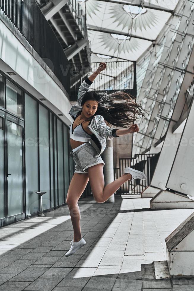 Schönheit in Bewegung. in voller Länge von einer attraktiven jungen Frau in Freizeitkleidung, die beim Springen im Freien wegschaut und gestikuliert foto