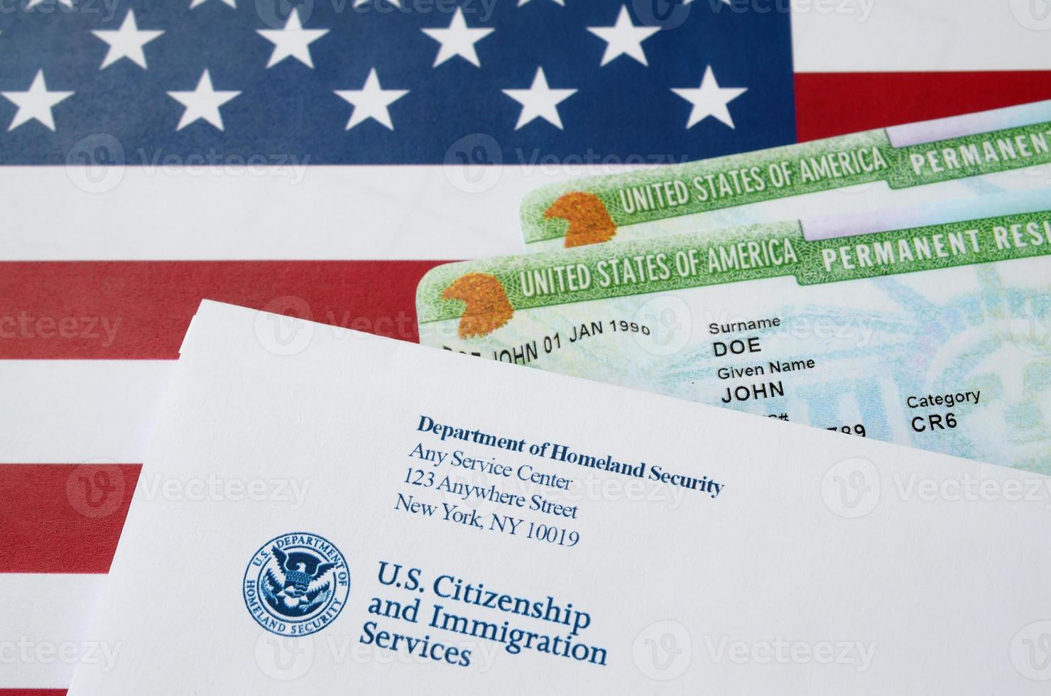 United States Permanent Resident Green Cards aus der DV-Lotterie liegen auf der Flagge der Vereinigten Staaten mit Umschlag vom Department of Homeland Security foto