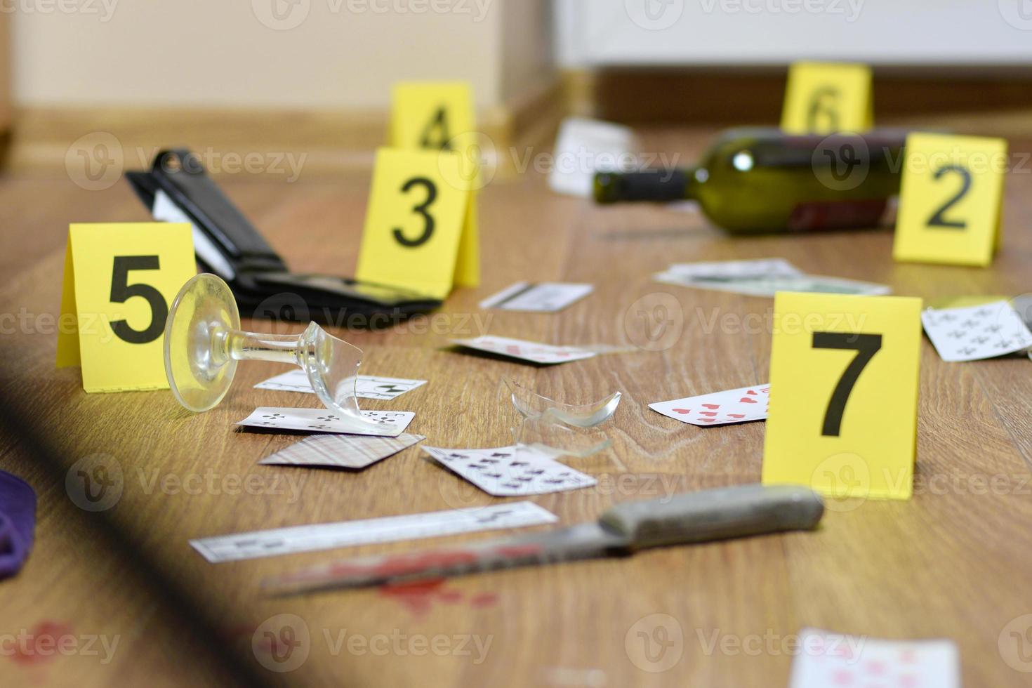 Tatortermittlung - Nummerierung der Beweismittel nach dem Mord in der Wohnung. viele Spielkarten, Portemonnaie und eine Flasche Wein als Beweismittel foto