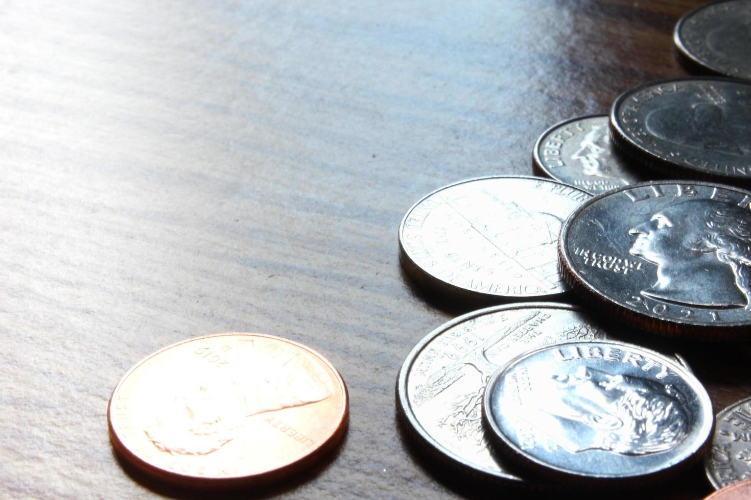 Dollarmünzen verstreut auf einem Holztisch, foto