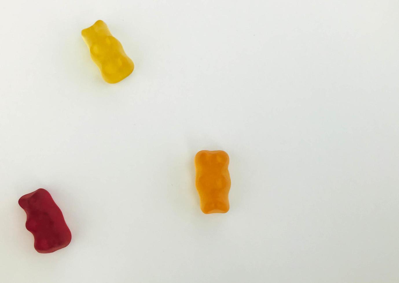 Gummibärchen auf einem weißen, matten Hintergrund. Roter, gelber und orangefarbener Bär liegen auf dem Tisch. Bonbons aus eigener Herstellung. Bonbons zum Dekorieren von Kuchen und Gebäck foto
