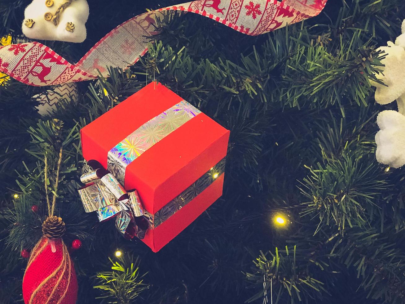 festliche bunte schöne glänzende ausgefallene kugeln, spielzeug, geschenkboxen, dekorationen auf dem weihnachtsgrünen baum mit nadeln und zweigen für das neue jahr. Hintergrund, Textur foto
