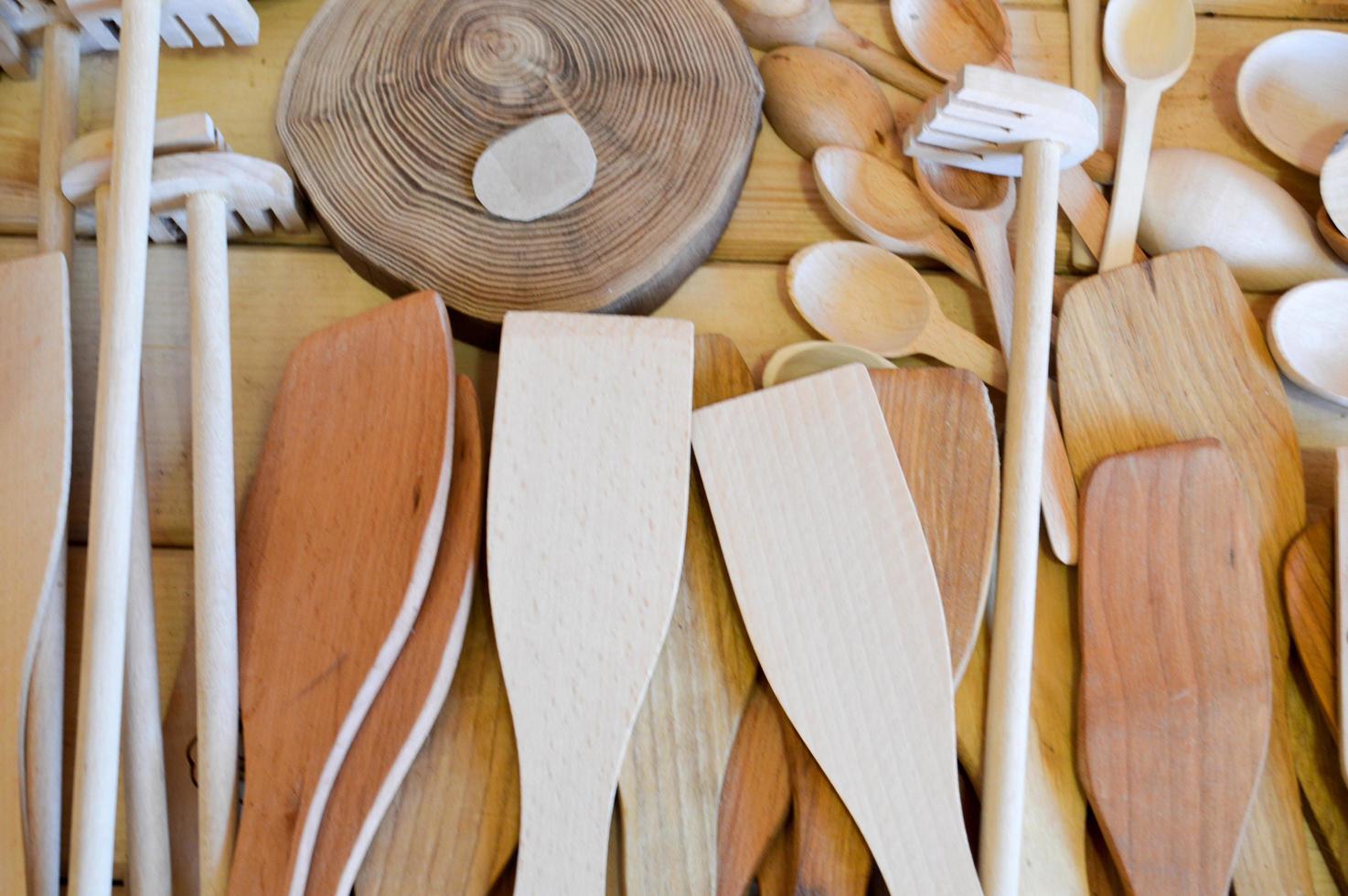 traditionelle küchengeräte aus naturholz, geschirr, löffel, schaufeln. der Hintergrund foto