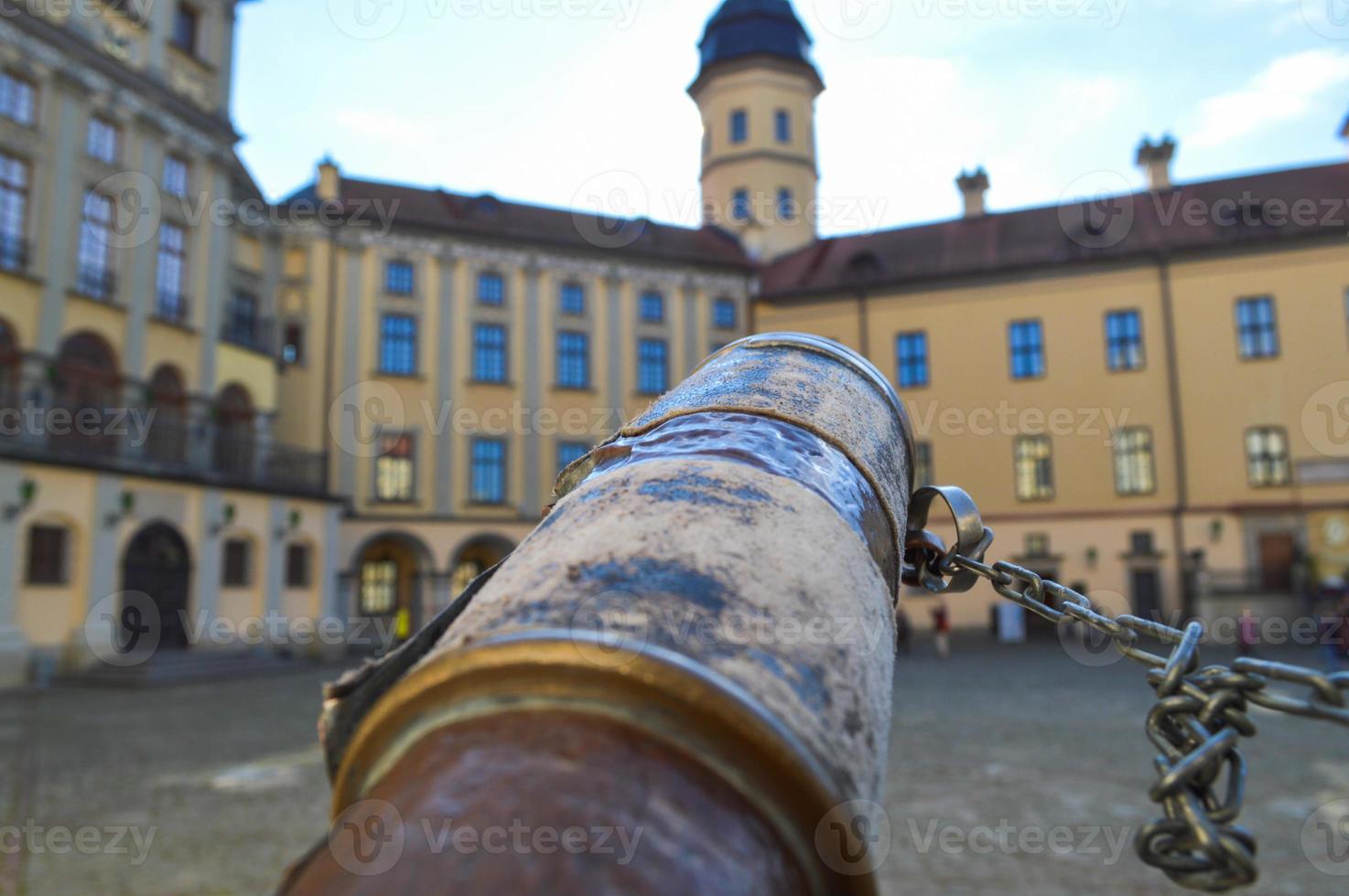 ein blick von einem alten alten fernglas auf ein europäisches mittelalterliches touristengebäude, eine burg, ein palast mit einer spitze und einem turm foto