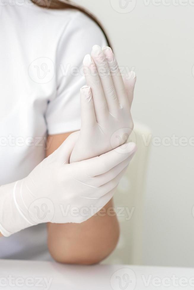 weibliche hände, die schutzhandschuhe anziehen foto