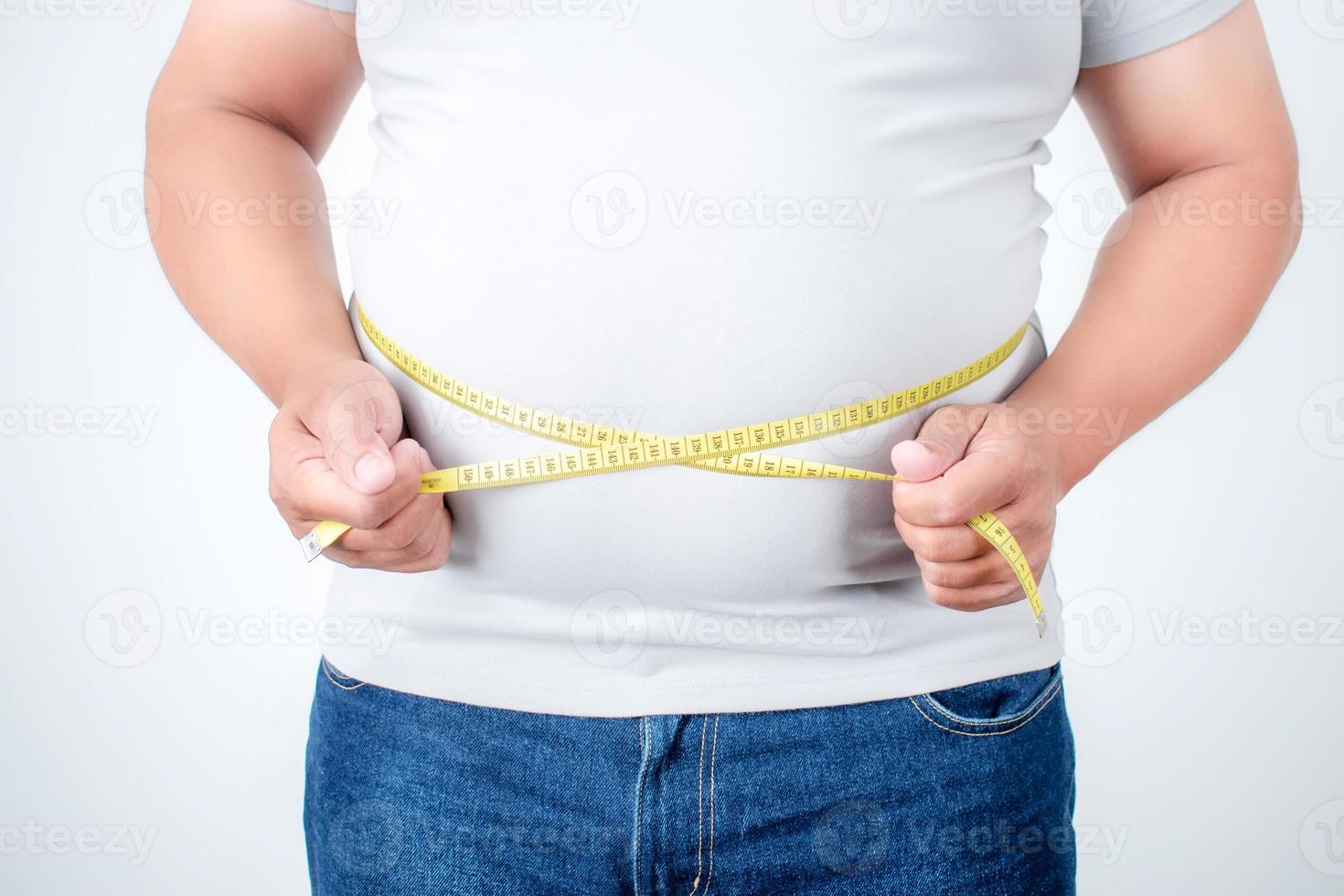 Übergewichtige Männer messen sein Bauchfett auf weißem Hintergrund. foto