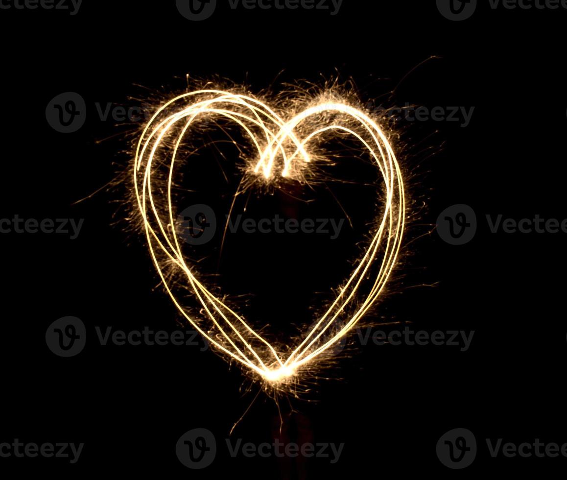 Herzform bei Nacht durch Feuerwerk Wunderkerzen foto