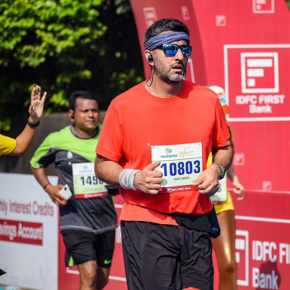 neu delhi, indien - 16. oktober 2022 - vedanta delhi halbmarathonrennen nach covid, bei dem die marathonteilnehmer kurz vor dem überqueren der ziellinie stehen, delhi halbmarathon 2022 foto