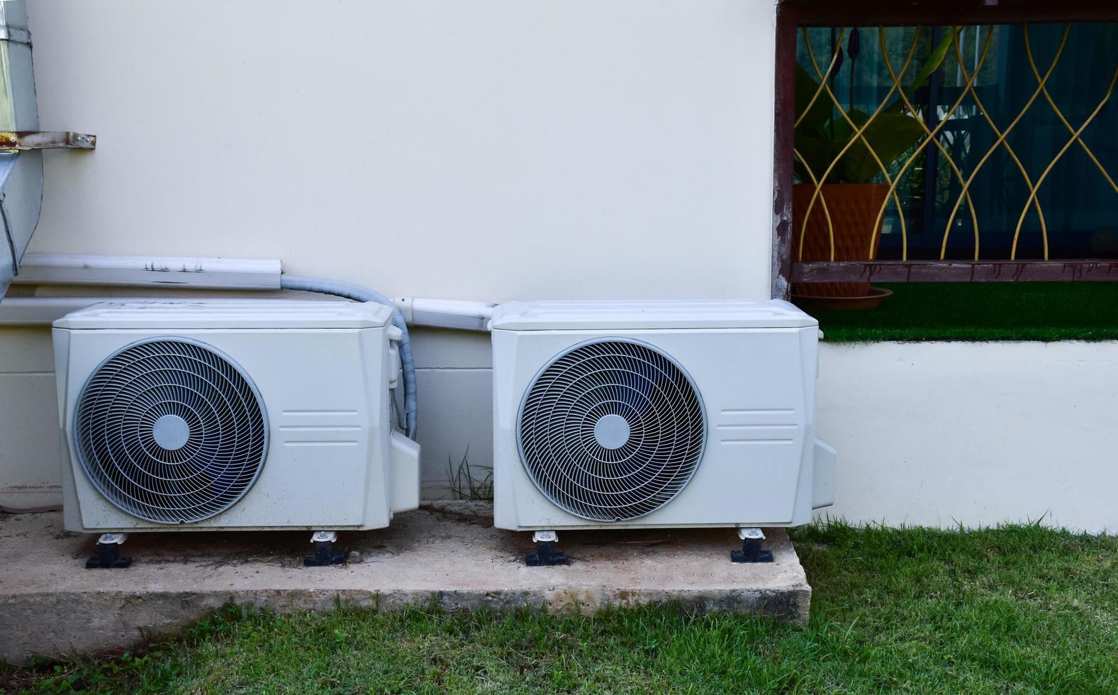 Weiße zwei Einheiten des Klimaanlagenventilators, die auf dem Zementboden des Gebäudes installiert sind, weicher und selektiver Fokus. foto