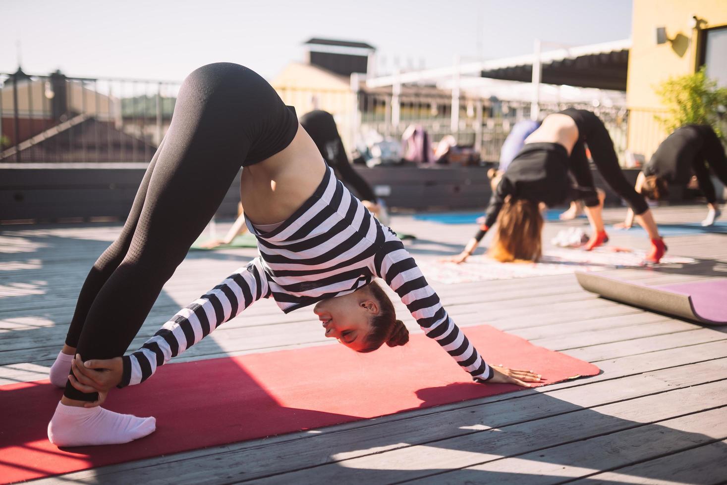 Yogi-Frau und eine vielfältige Gruppe sportlicher Menschen, die Yoga praktizieren foto