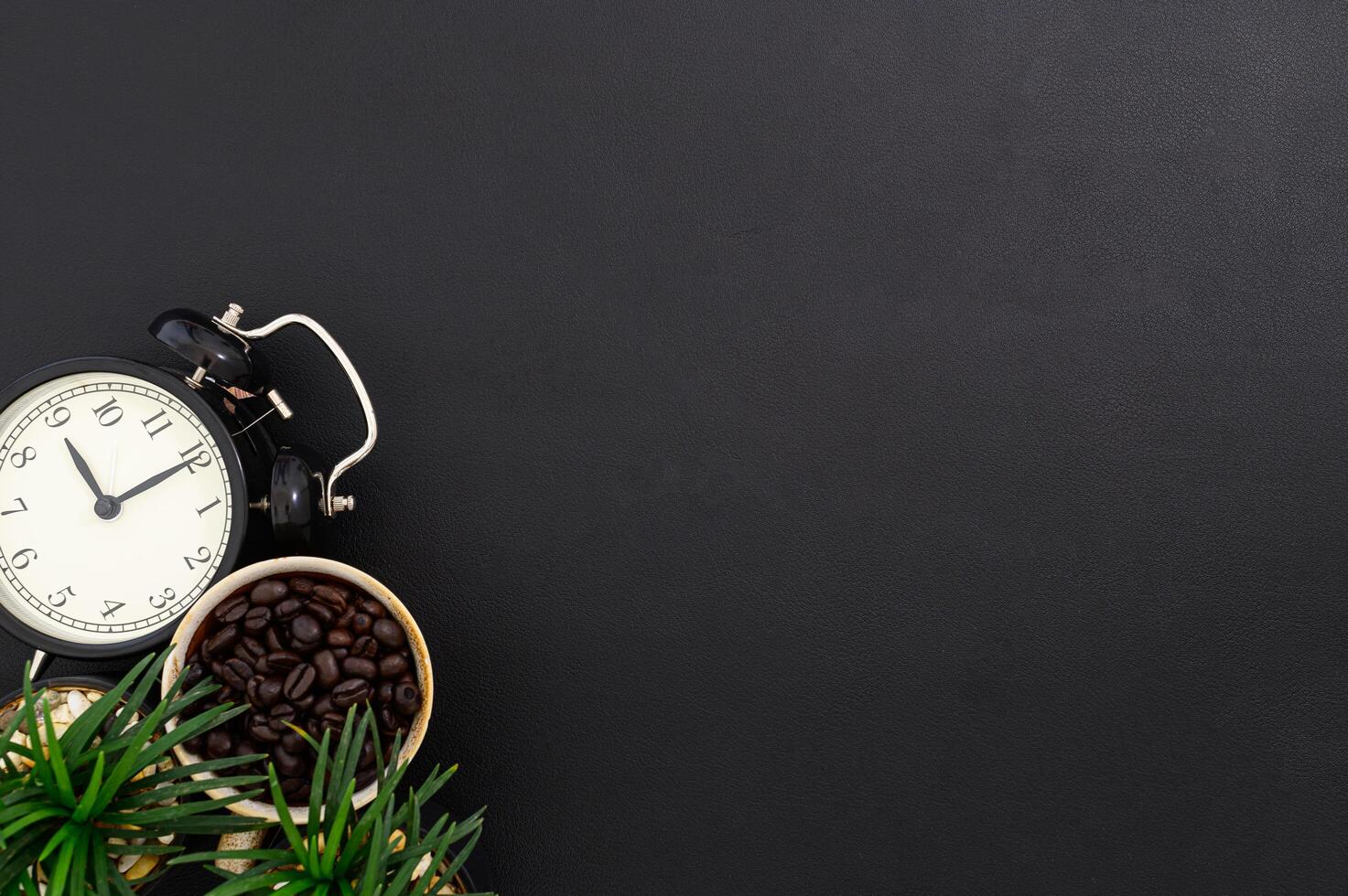 Tasse mit Kaffeebohnen und einer Uhr auf dem Schreibtisch foto