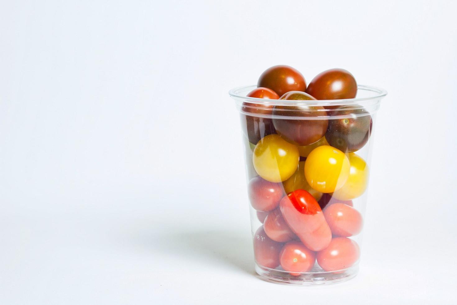 Kirschtomaten in transparenter Plastikbox foto