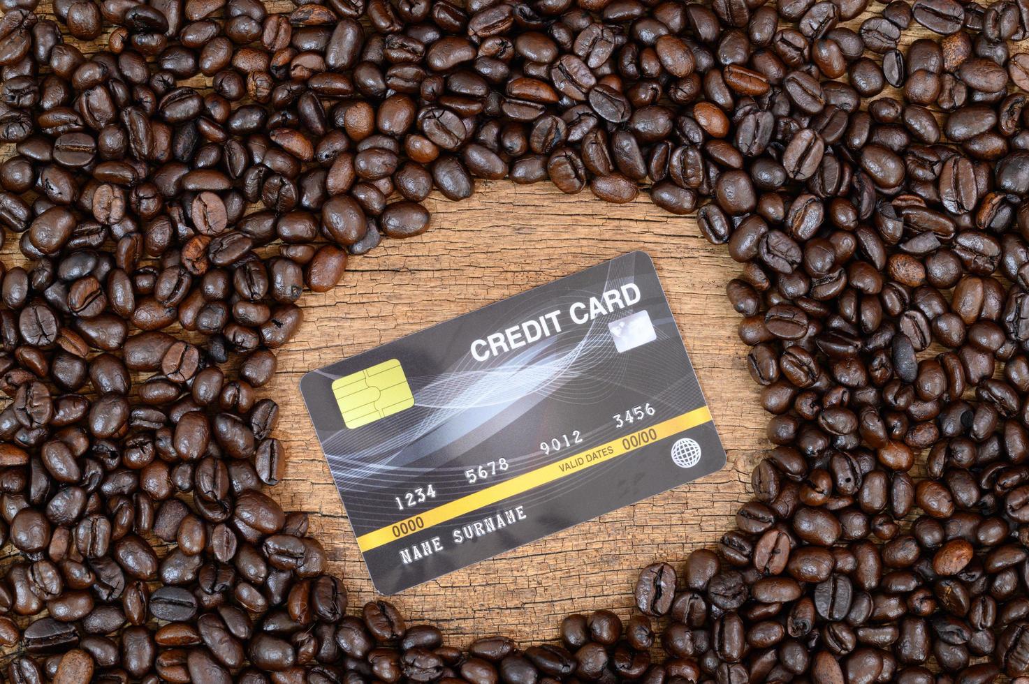 Kreditkarte und Kaffeebohnen auf dem Schreibtisch foto