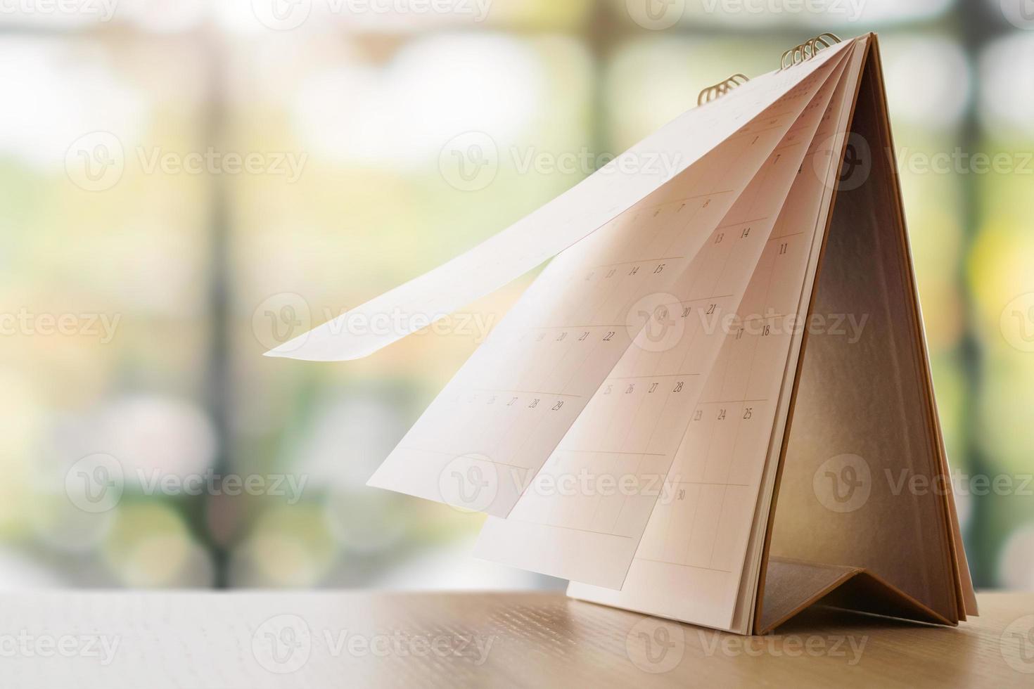 tischkalender auf dem tisch mit unscharfem bokeh-hintergrundtermin und geschäftstreffenkonzept foto