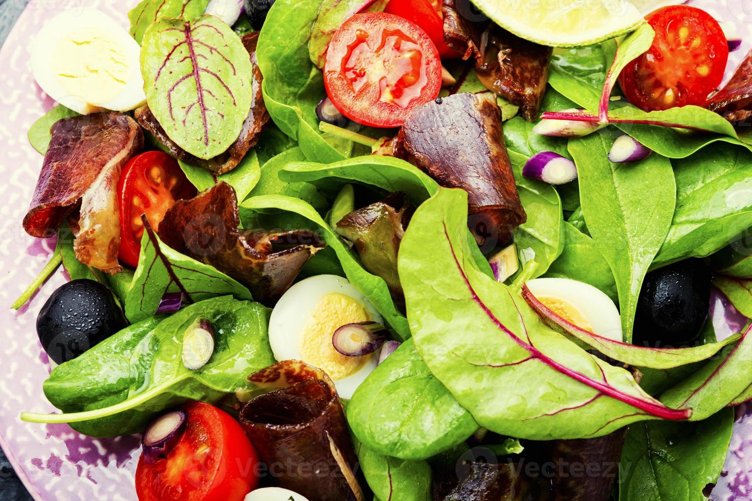 leckerer Salat mit Gemüse, Kräutern und Schinken foto