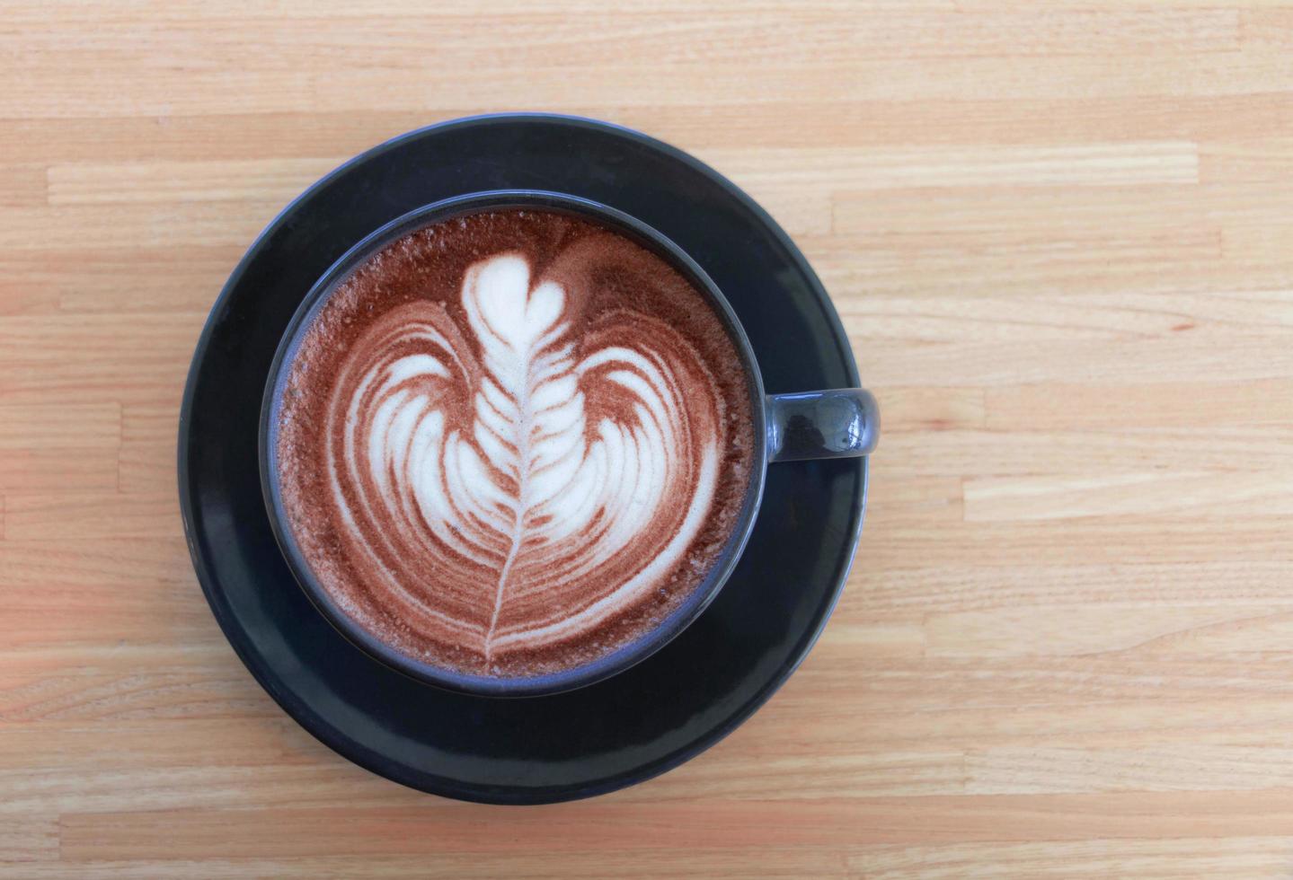 draufsicht auf heißen kakao mit schaumschaumkunst in schwarzer keramiktasse foto