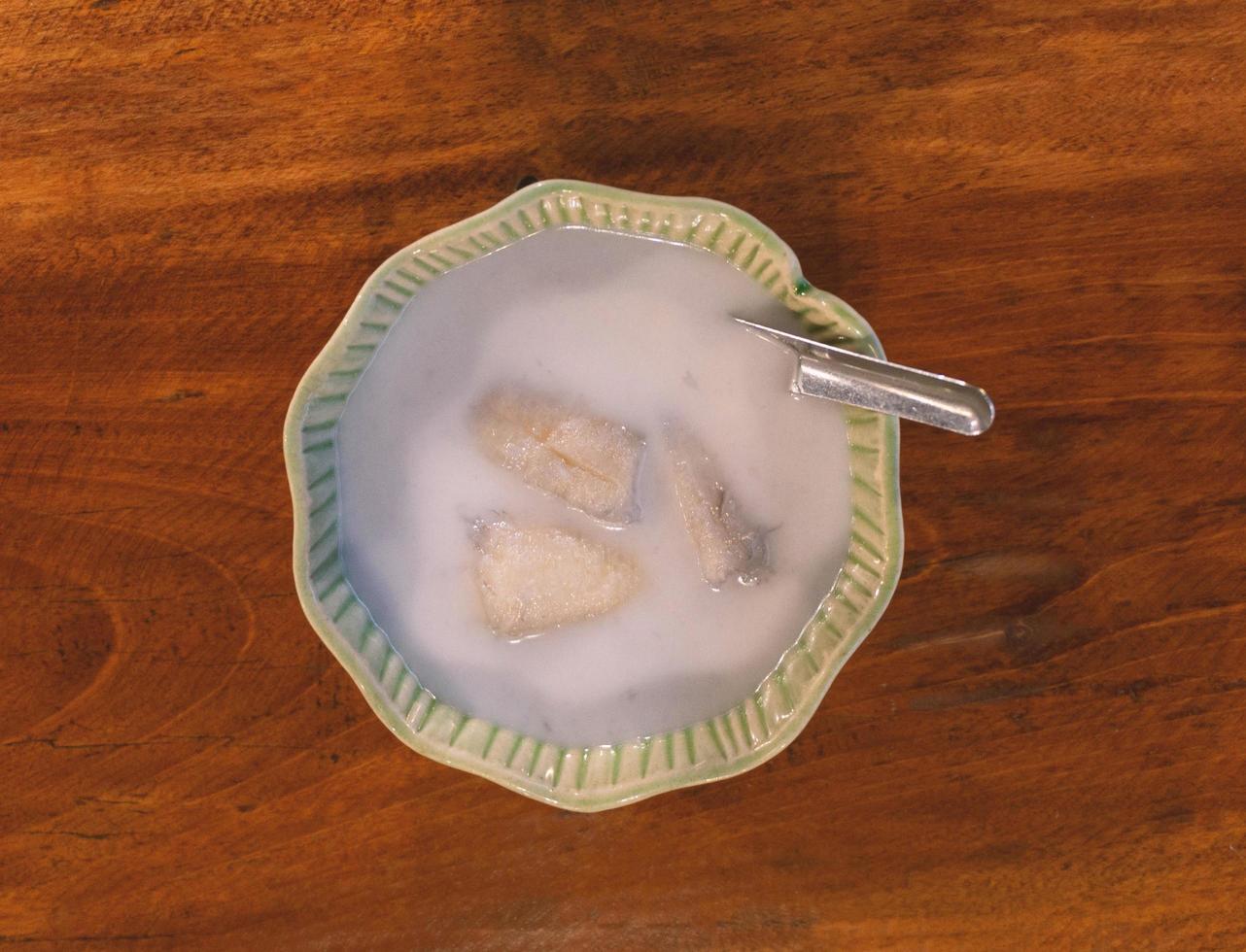 thailändische banane in kokosmilch auf holztisch foto