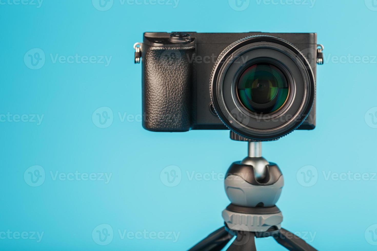 professionelle Kamera auf einem Stativ, auf blauem Hintergrund. Nehmen Sie Videos und Fotos für Ihren Blog oder Bericht auf.