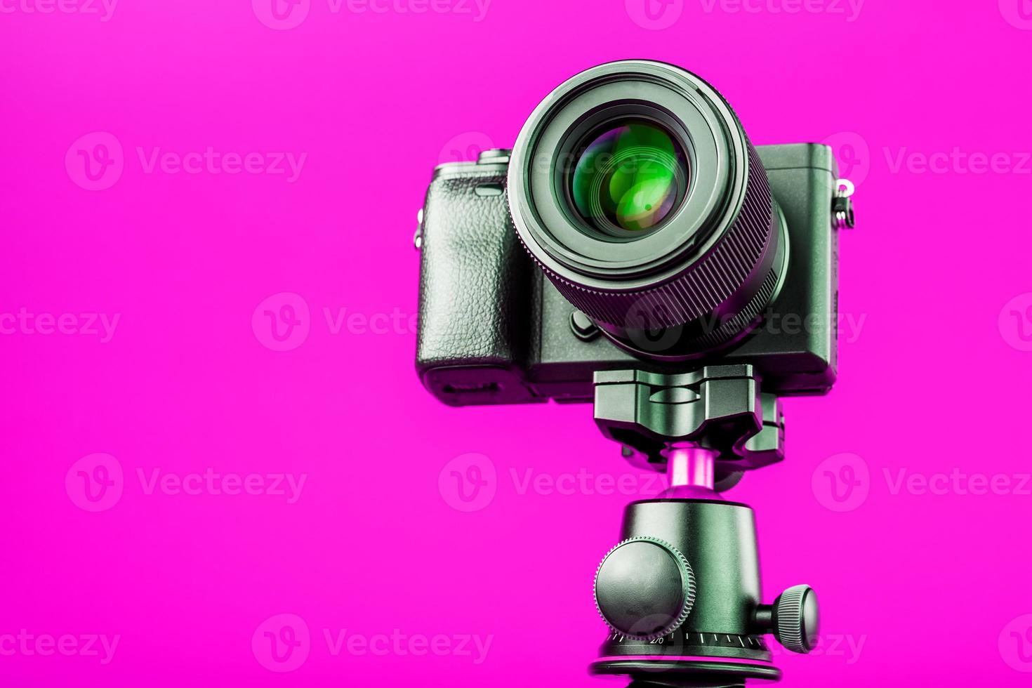 professionelle kamera auf einem stativ, auf einem rosa hintergrund. Nehmen Sie Videos und Fotos für Ihren Blog oder Bericht auf.