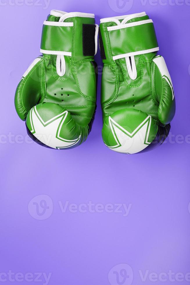 grüne Boxhandschuhe auf einem lila Hintergrund. Nahansicht. foto