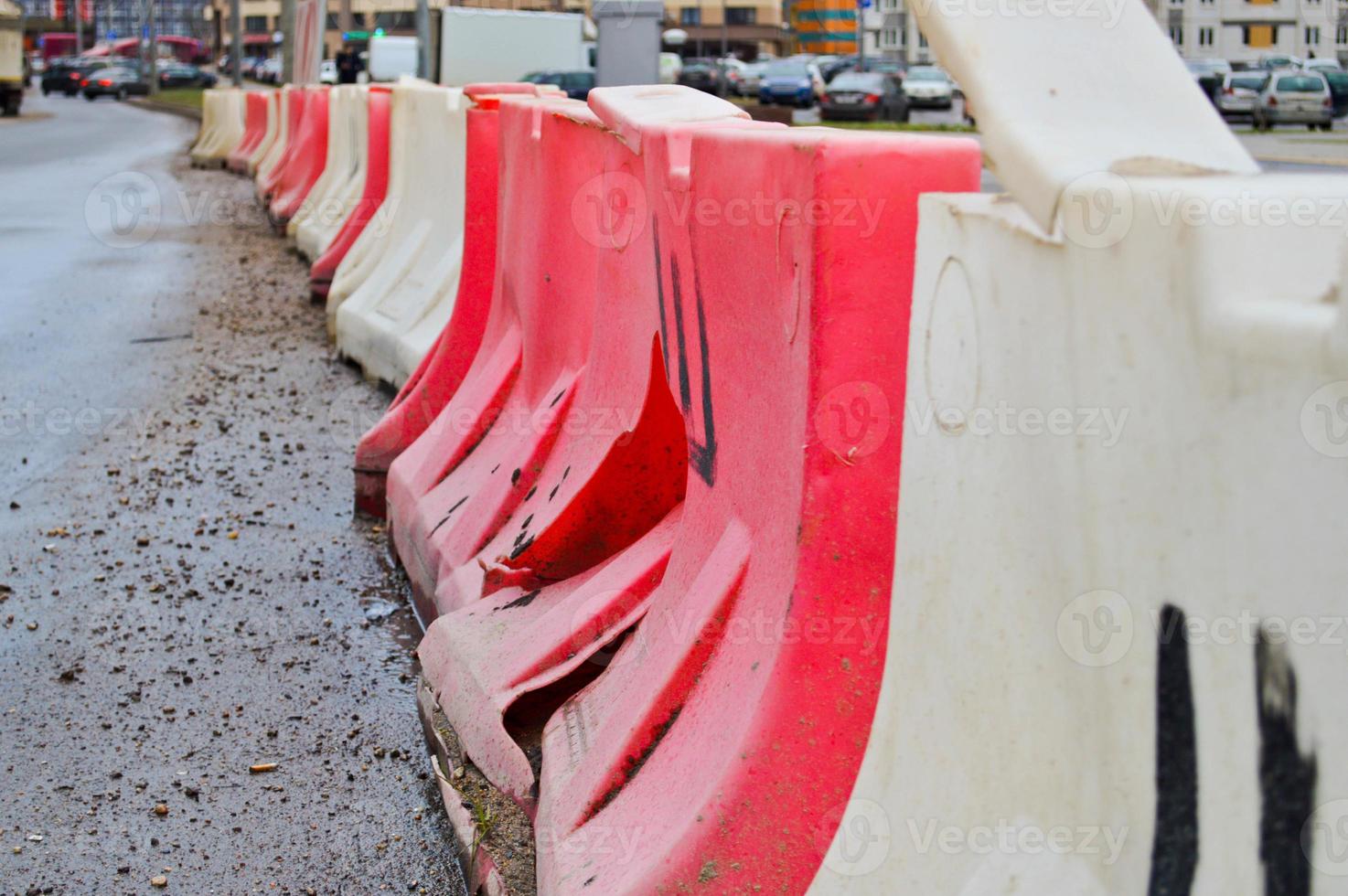 große, mit Wasser gefüllte, rote und weiße Gehäuseblöcke aus Kunststoff für die Verkehrssicherheit bei Straßenreparaturen foto