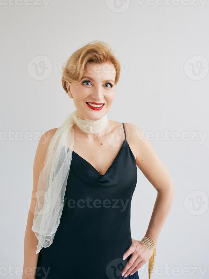 modische, stilvolle, schöne, reife Frau in Kleid und Schal. Stil, Mode, Anti-Age-Konzept foto