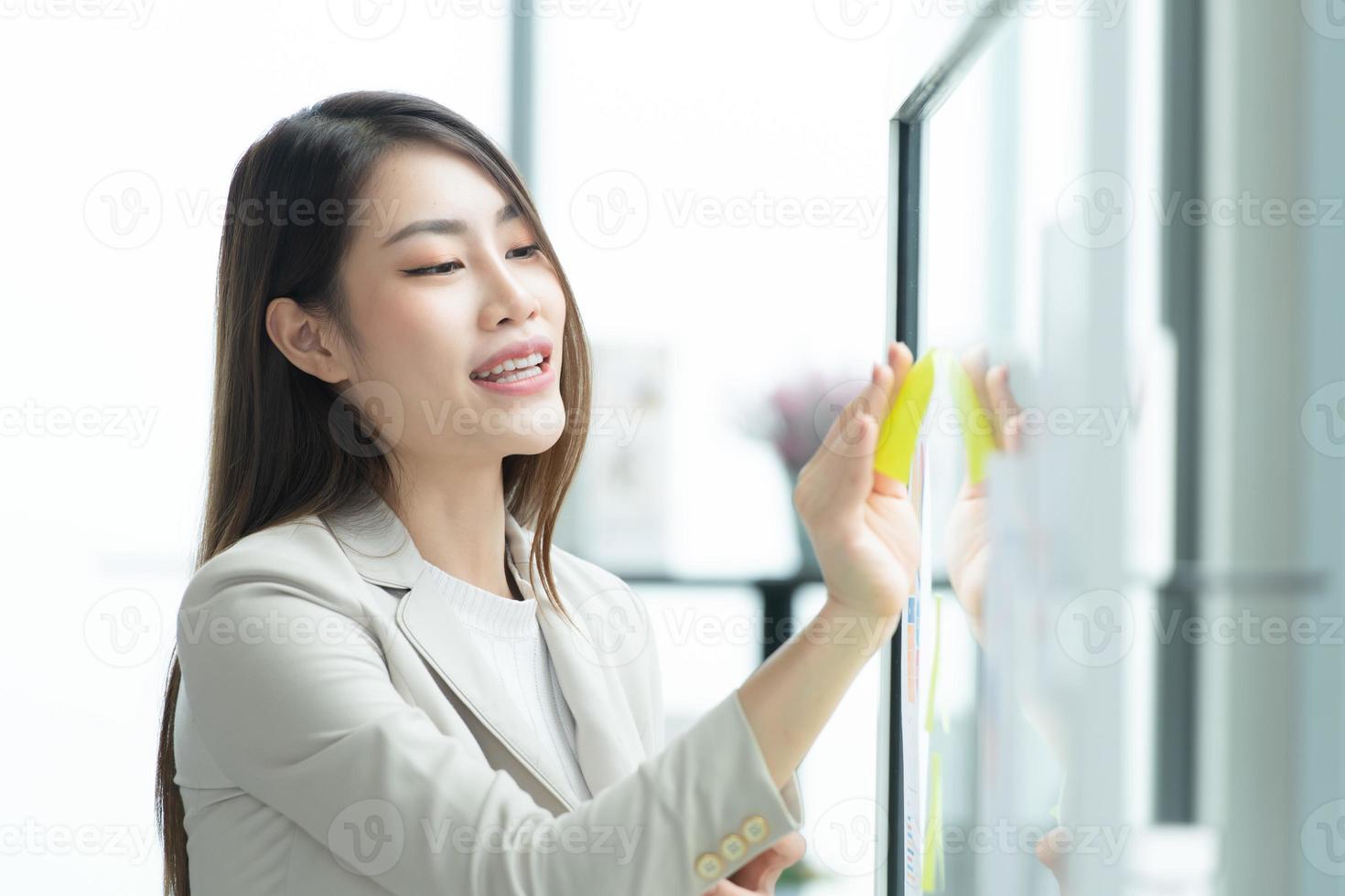 junge unternehmer in asien organisieren treffen zum brainstormen und überprüfen von informationen über glastafeln foto