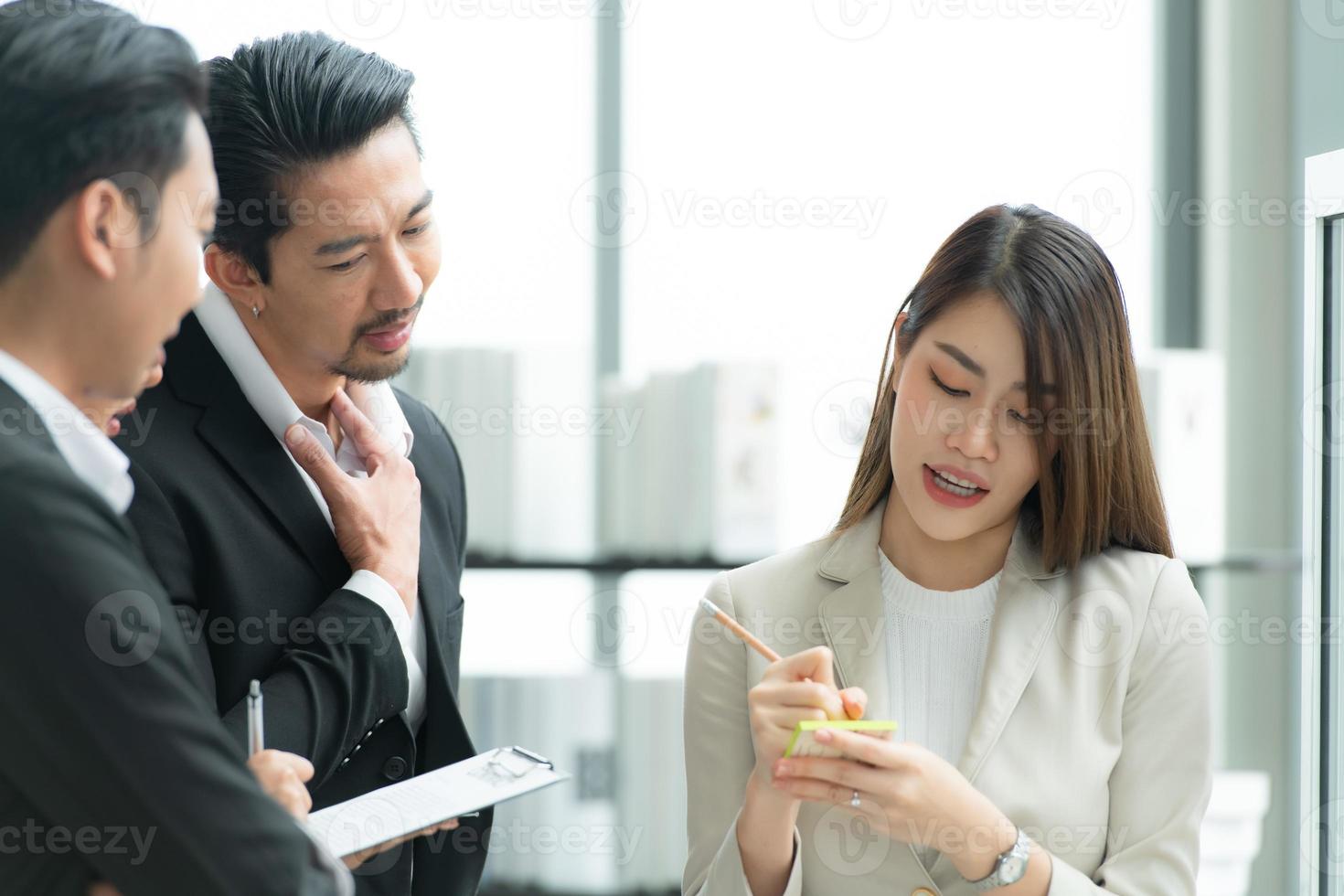 junge unternehmer in asien organisieren treffen zum brainstormen und überprüfen von informationen über glastafeln foto