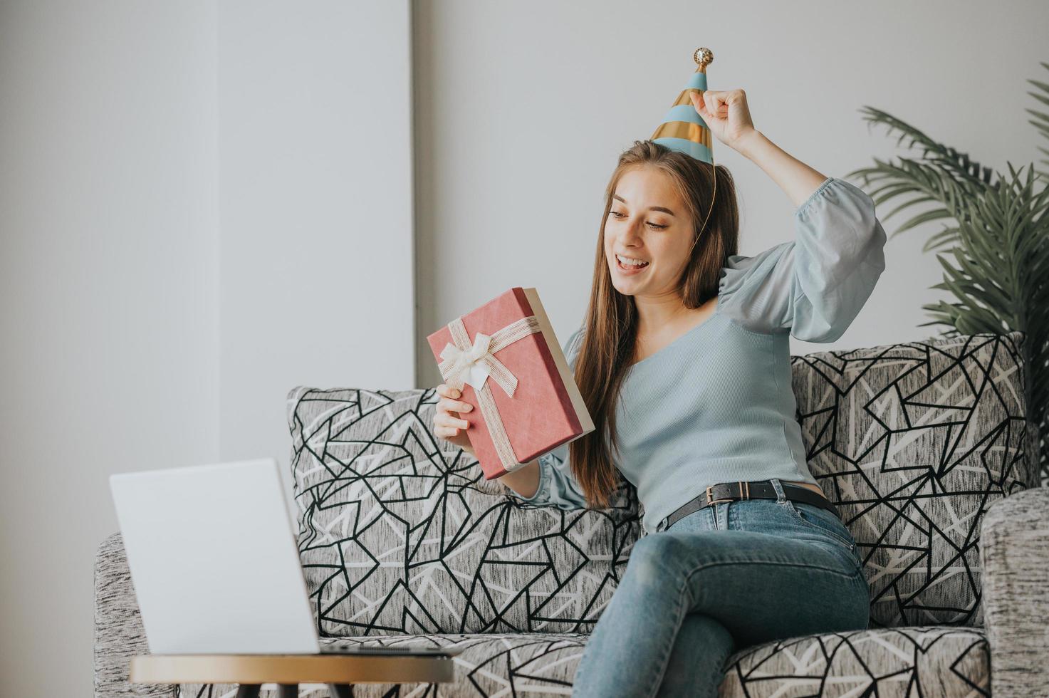 Frau, die einen Geburtstag auf einem Videoanruf feiert foto