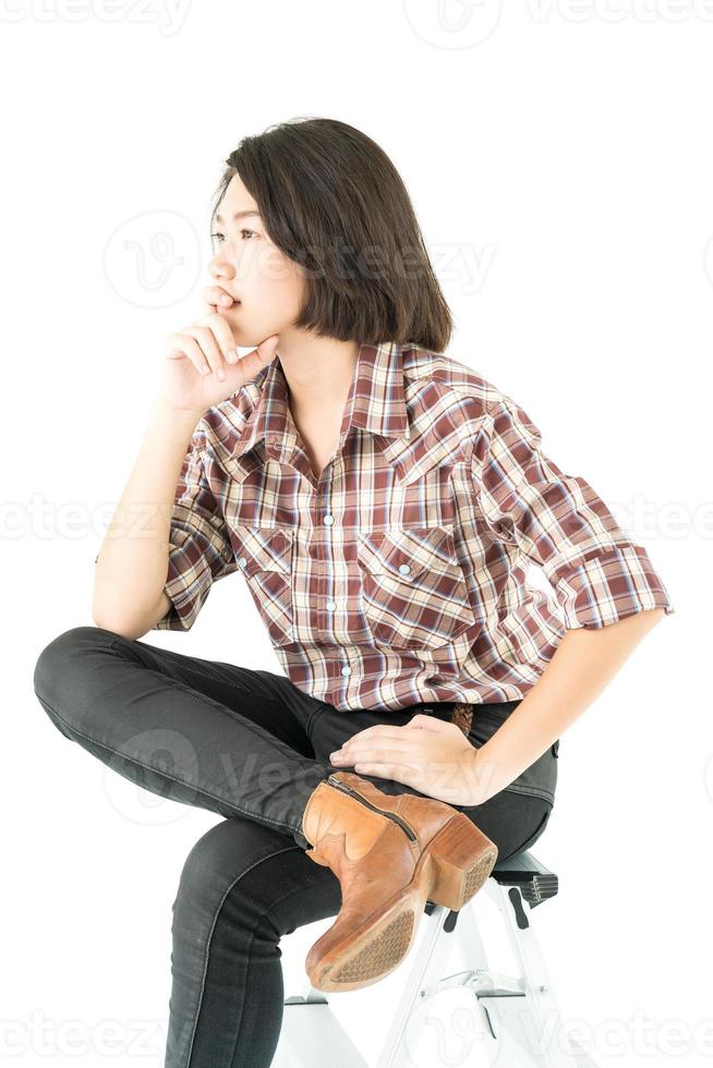 junge frau in einem karierten hemd, das im studio auf weiß aufwirft foto