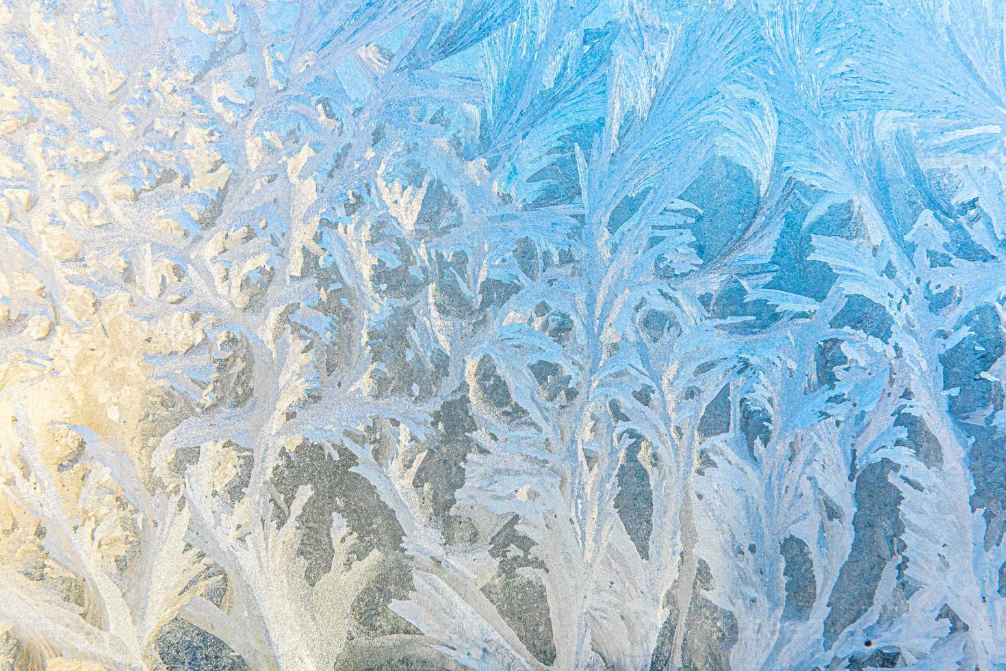 gefrorenes winterfenster mit glänzender eisfrostmusterbeschaffenheit. Weihnachtswundersymbol, abstrakter Hintergrund. extreme nördliche niedrige Temperatur, natürlicher Eisschnee auf frostigem Glas, kühles Winterwetter im Freien. foto