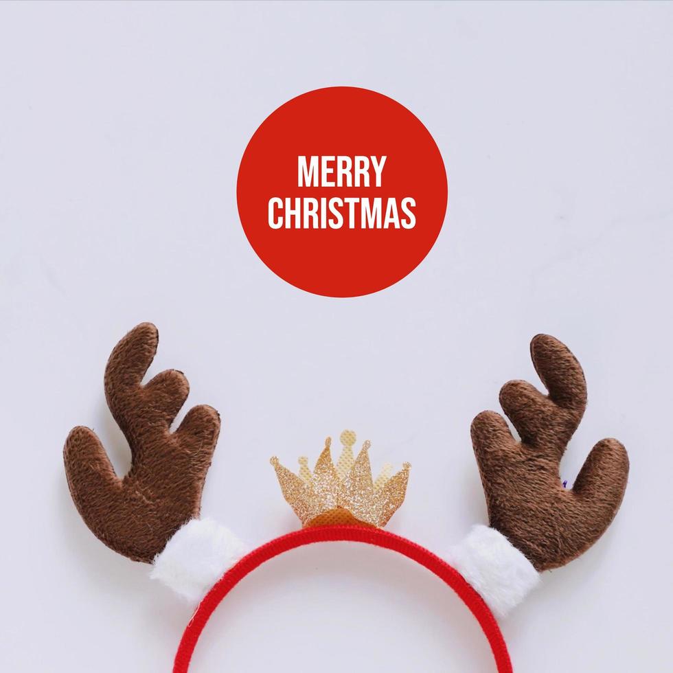 ausgefallenes stirnband mit dekorativer form des rentiergeweihs für weihnachtsfeier und feier auf weißem marmorhintergrund, frohes weihnachtskonzept foto