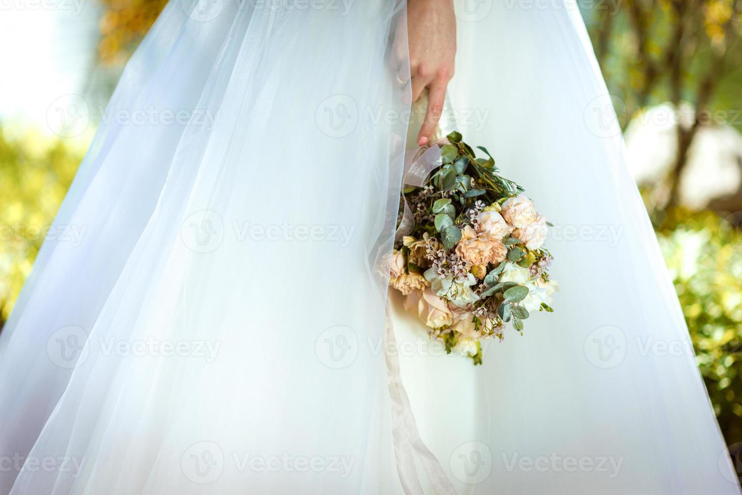 die braut hält einen hochzeitsstrauß in den händen, hochzeitsblumen. foto