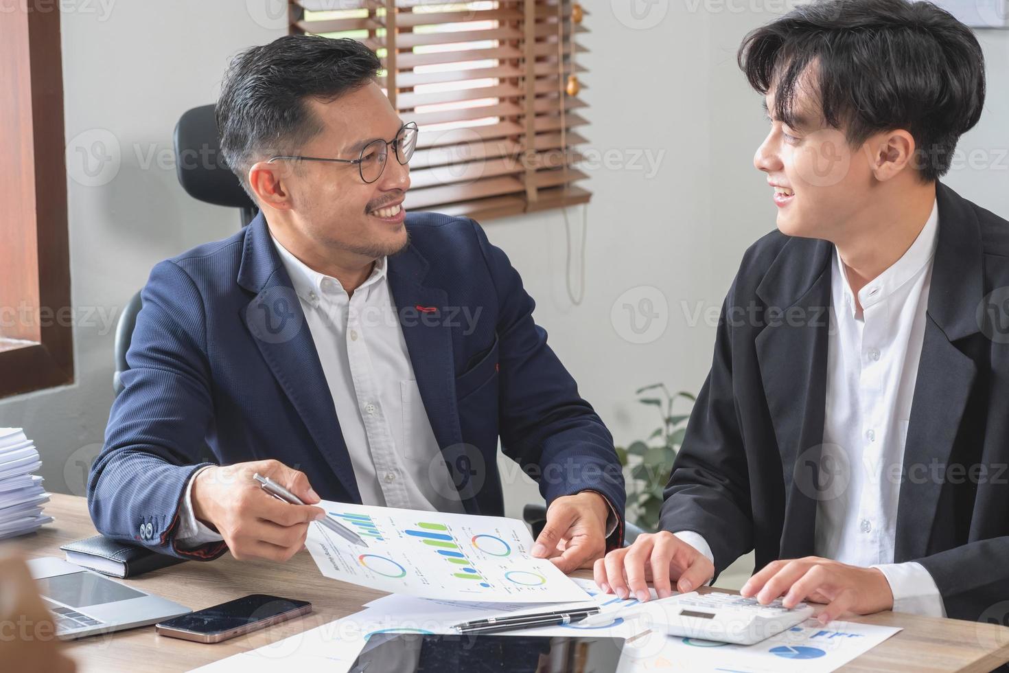 Team von Unternehmen verwendet Taschenrechner und Computer-Laptop-Tablets zur Grafikanalyse, um Marketingstrategien zu planen und rentable Investitionen für das Unternehmen zu tätigen. foto