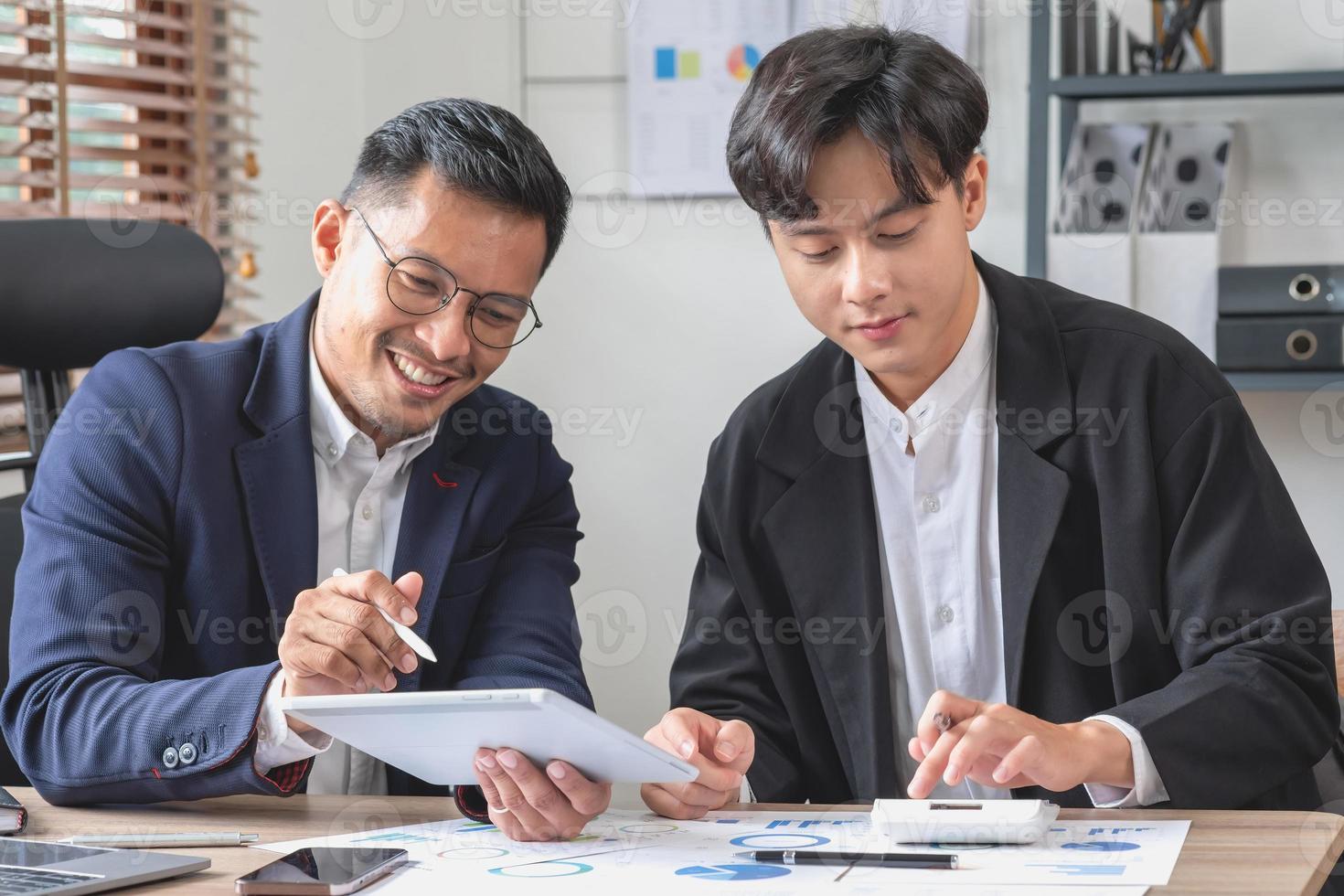 Team von Unternehmen verwendet Taschenrechner und Computer-Laptop-Tablets zur Grafikanalyse, um Marketingstrategien zu planen und rentable Investitionen für das Unternehmen zu tätigen. foto