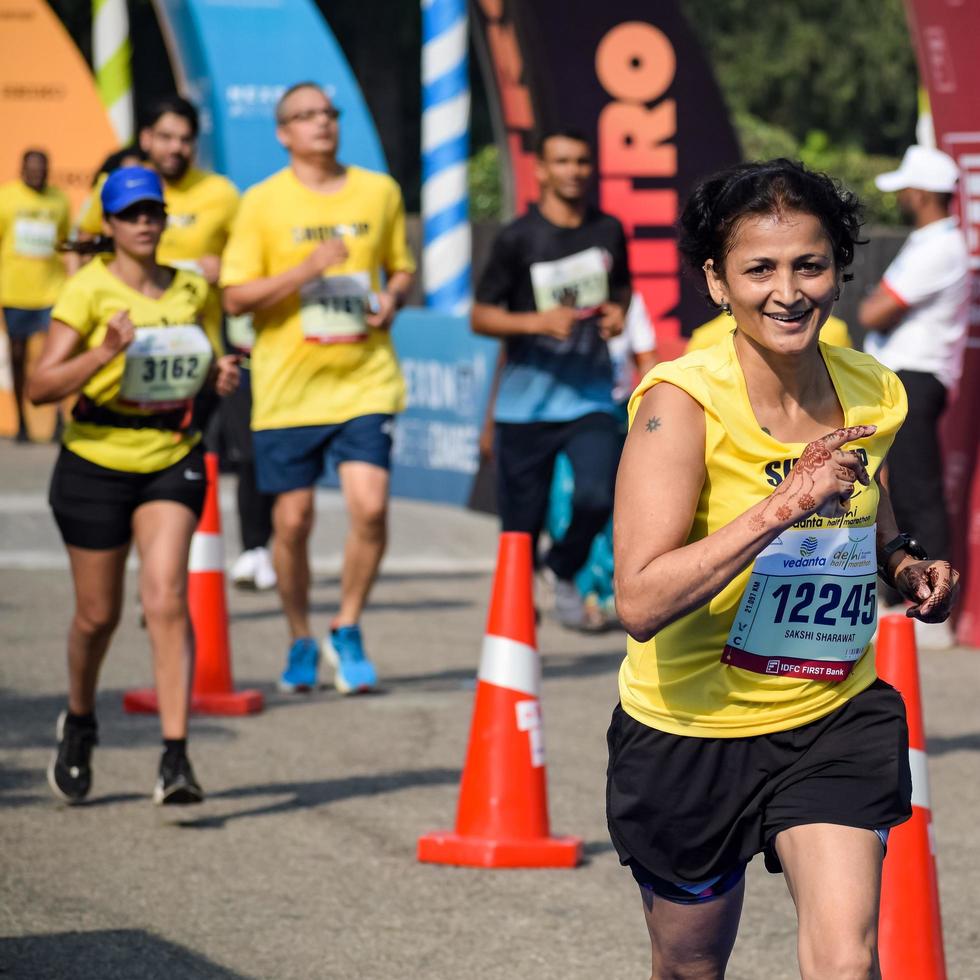 neu delhi, indien - 16. oktober 2022 - vedanta delhi halbmarathonrennen nach covid, bei dem die marathonteilnehmer kurz vor dem überqueren der ziellinie stehen, delhi halbmarathon 2022 foto