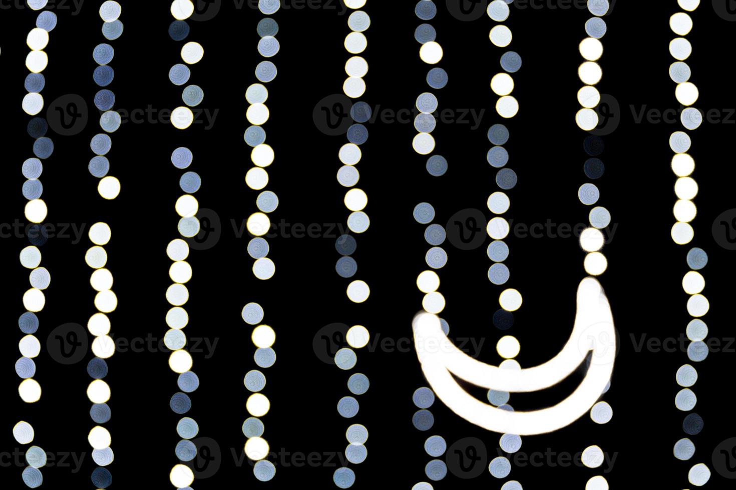 abstraktes bokeh der weißen stadtlichter auf schwarzem hintergrund. defokussiert und verschwommen mit Mond aus Lichtern foto
