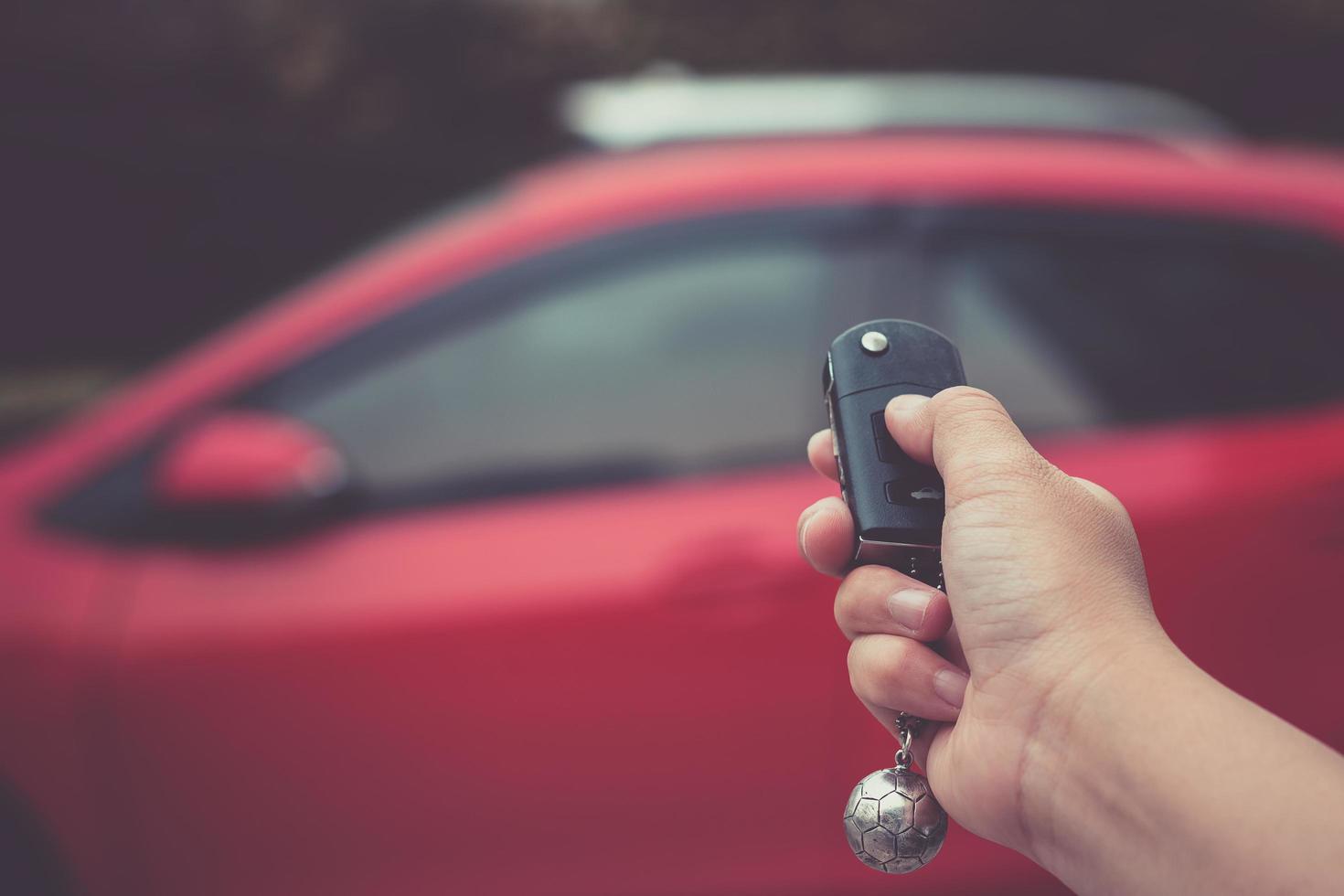 Mann drückt Knopf auf Fernbedienung Autoschlüssel foto