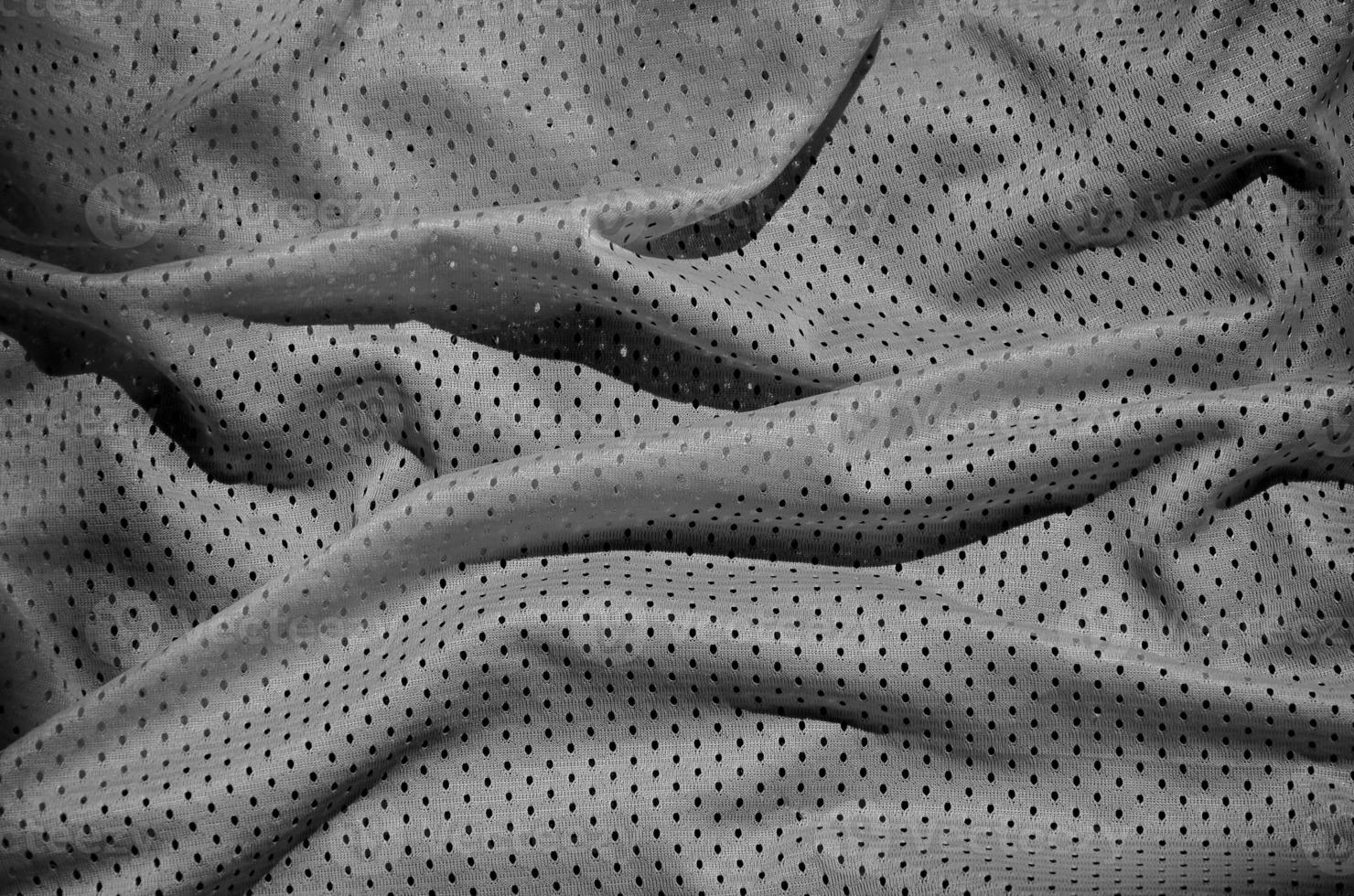 grauer sportbekleidungsstoff textur hintergrund. Draufsicht auf die Textiloberfläche aus grauem Stoff. dunkles Basketballshirt. foto