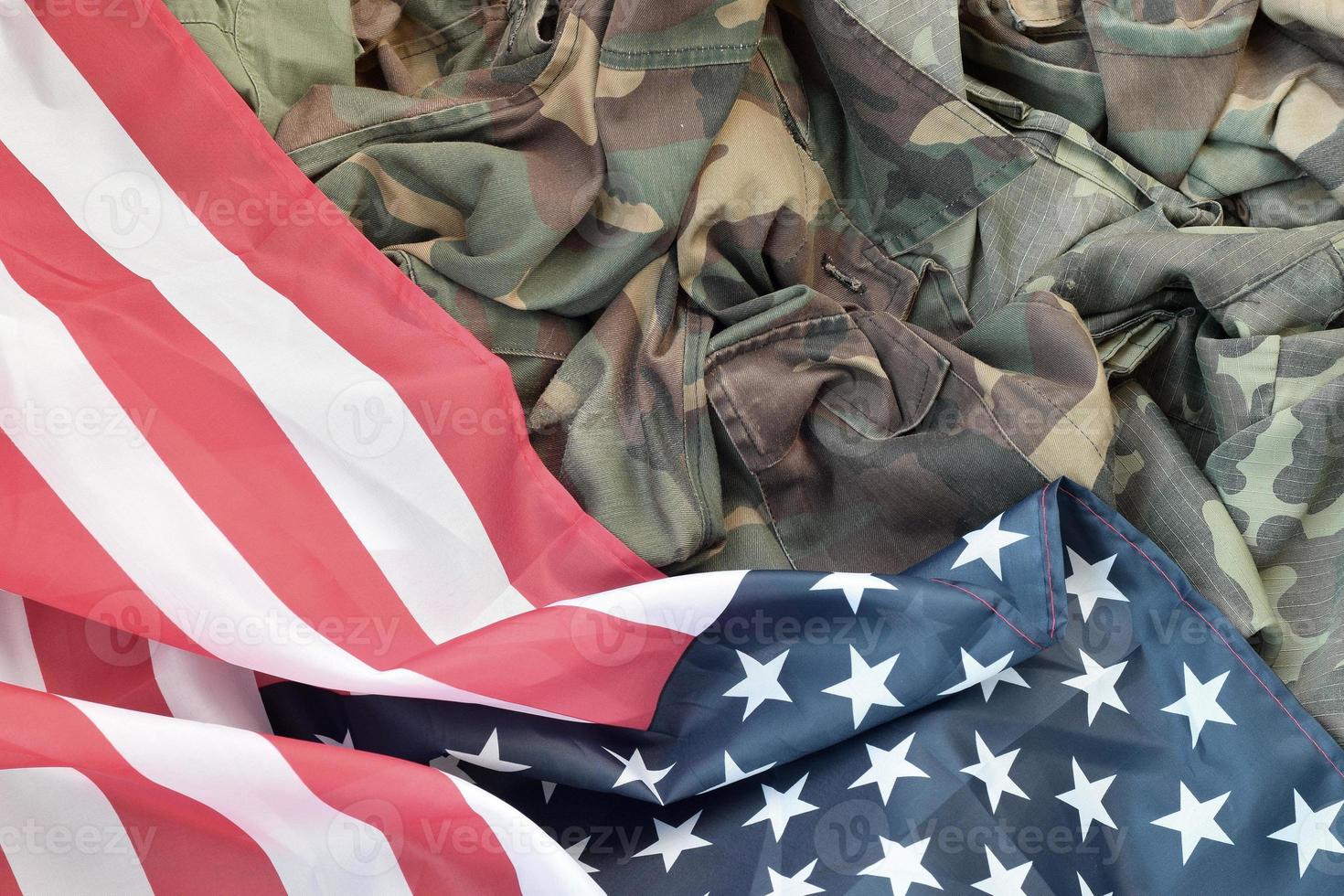 Flagge der Vereinigten Staaten von Amerika und gefaltete Militäruniformjacke. militärische symbole konzeptioneller hintergrundbanner für amerikanische patriotische feiertage foto