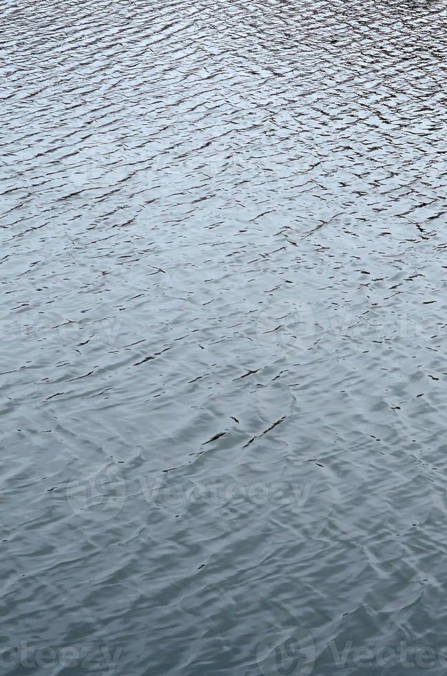 die Textur des Wassers im Fluss unter dem Einfluss des Windes. viele flache Wellen an der Wasseroberfläche foto