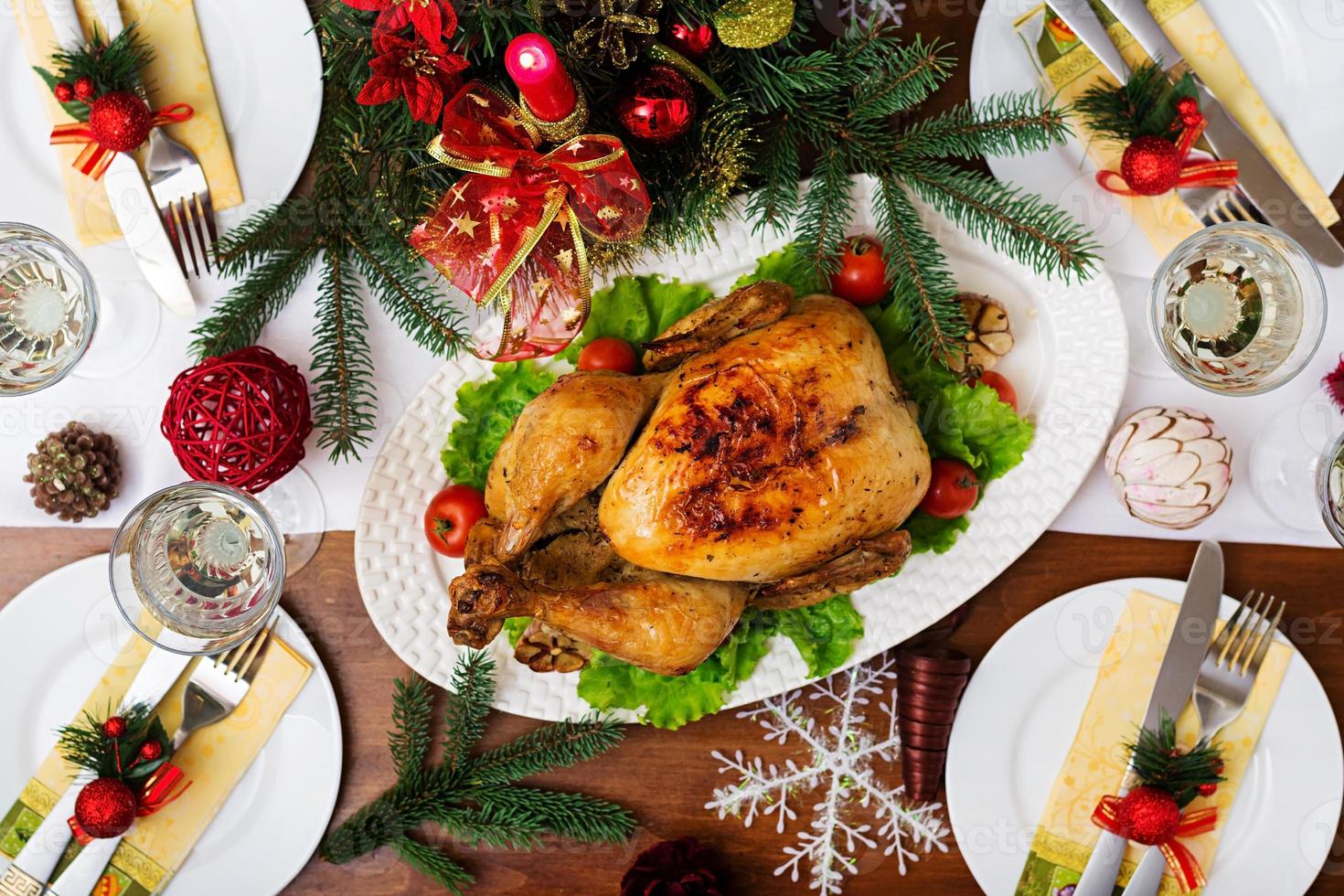 gebackener Truthahn oder Huhn. Der Weihnachtstisch wird mit einem Truthahn serviert, der mit leuchtendem Lametta und Kerzen dekoriert ist. Brathähnchen, Tisch. Weihnachtsessen. flach liegen. Ansicht von oben foto