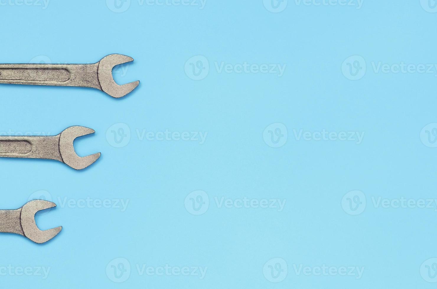 drei metallische schlüssel liegen auf texturhintergrund von modepastellblauem farbpapier foto