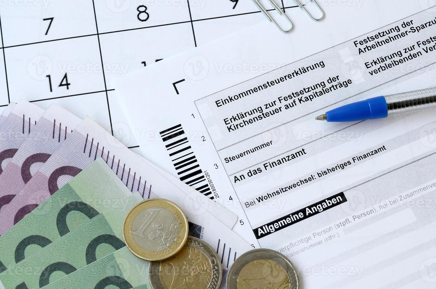 deutsches steuerformular mit stift und europäischen geldscheinen liegt im bürokalender. steuerzahler in deutschland verwenden euro-währung, um steuern zu zahlen foto