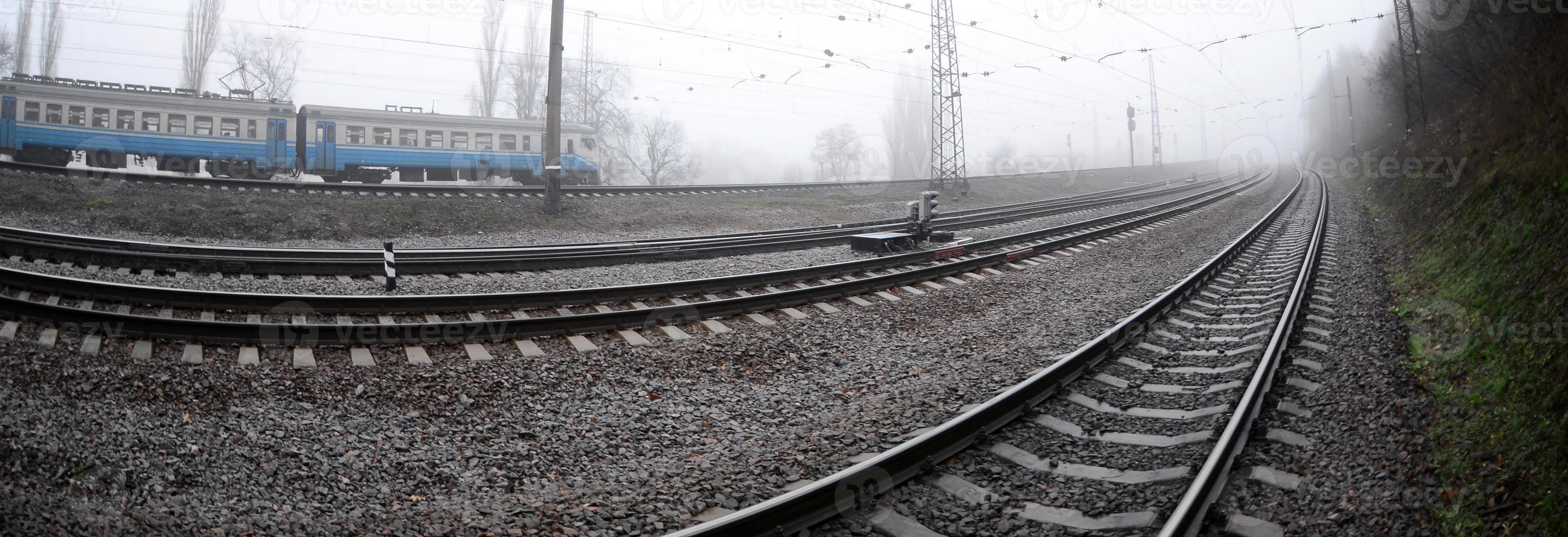 die ukrainische s-bahn rauscht an einem nebligen morgen die eisenbahn entlang. Fisheye-Foto mit erhöhter Verzerrung foto