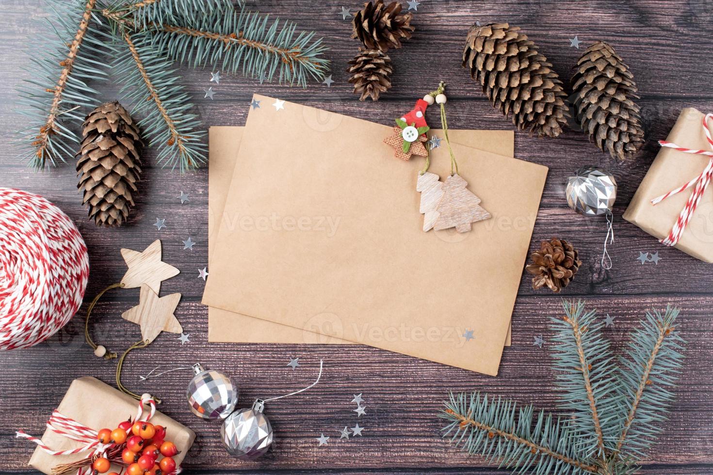 handwerksumschlag mit weihnachtsdekorationen und tannenzapfen draufsicht auf hölzernen hintergrund foto