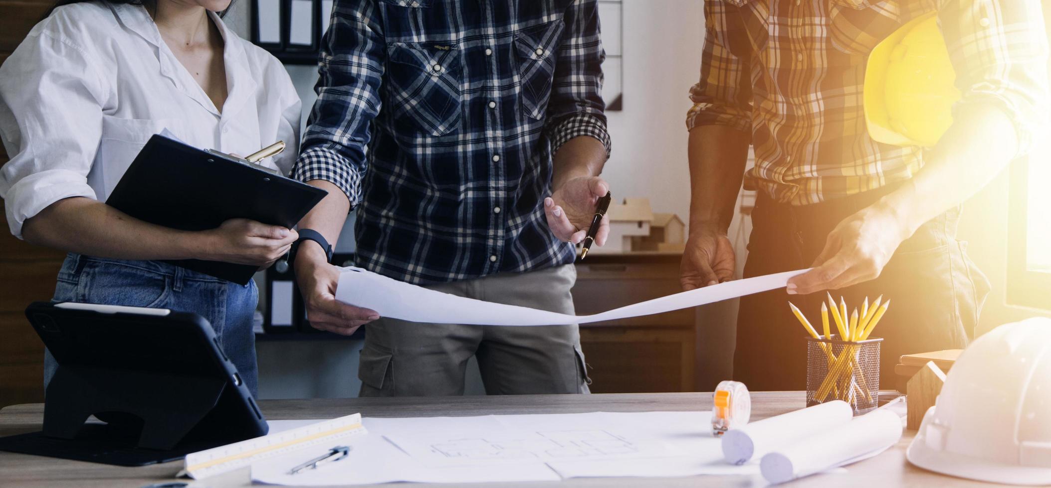 Bauingenieur, der an der Blaupause arbeitet, um große Geschäftsgebäude im Büro zu bauen. Engineering-Tools und Konstruktionskonzept. foto